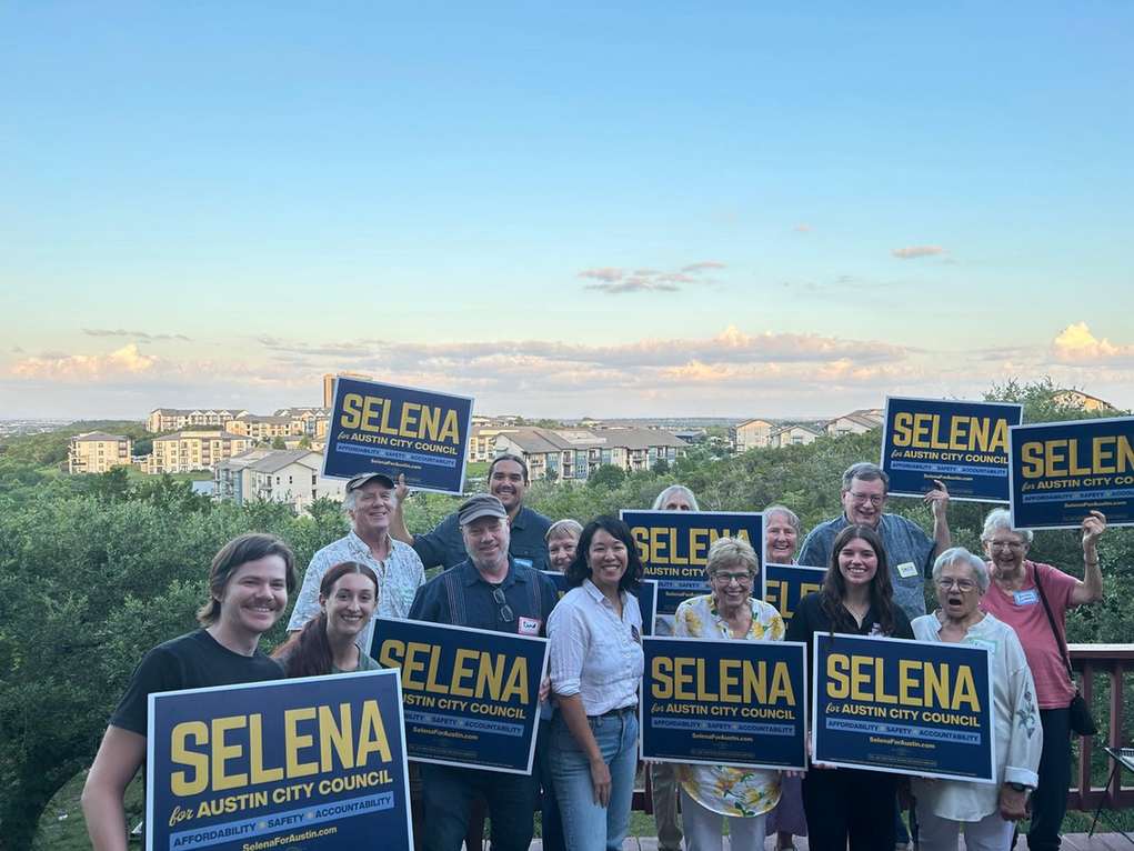District 8 supporters holding Selena for Austin yard signs